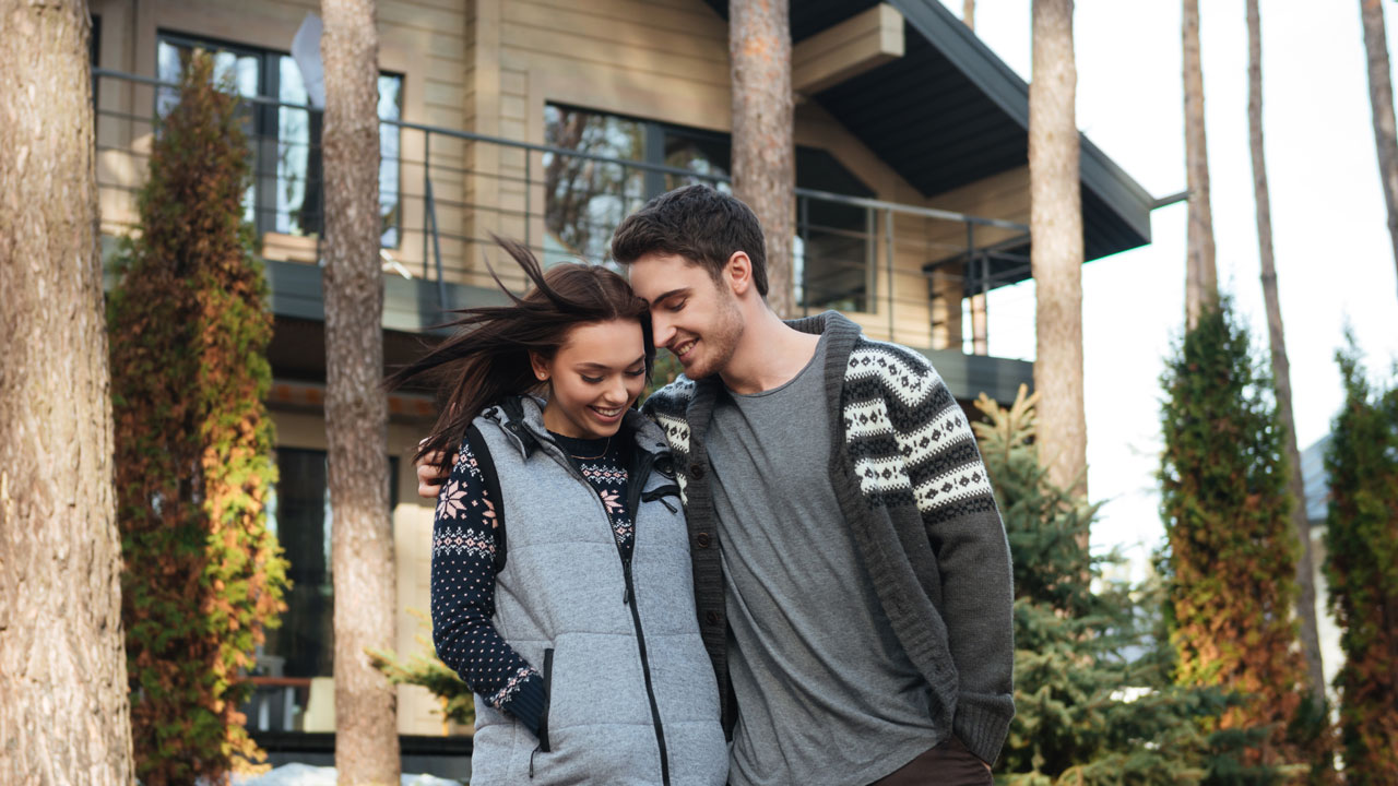 smiling couple outside their new home