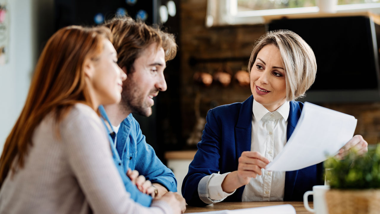 smiling financial woman talking with young couple